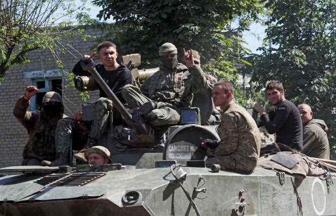 Members of the pro-Russian army board an armored vehicle in the town of Popasna in the Luhansk region of eastern Ukraine on June 2, 2022.
