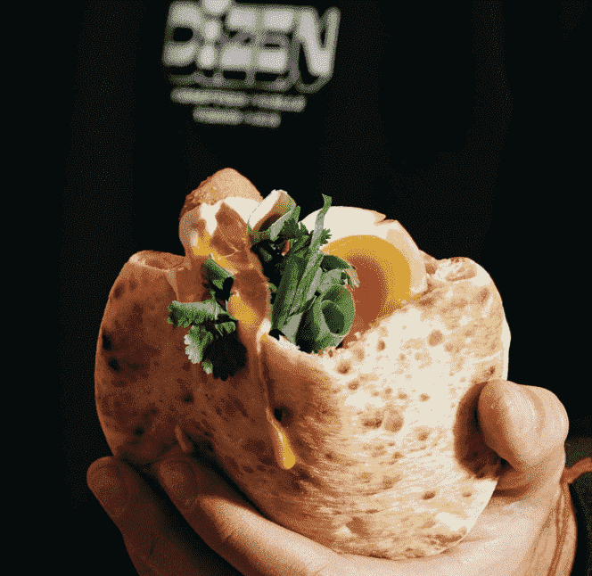 Fried eggplant, marinated soft-boiled egg, beetroot cooked in a salt crust, cabbage, celery, onion, infused potato, herbs, thina, zhoug, amba... in a pita, from Dizen, present at We Love Green 2022.