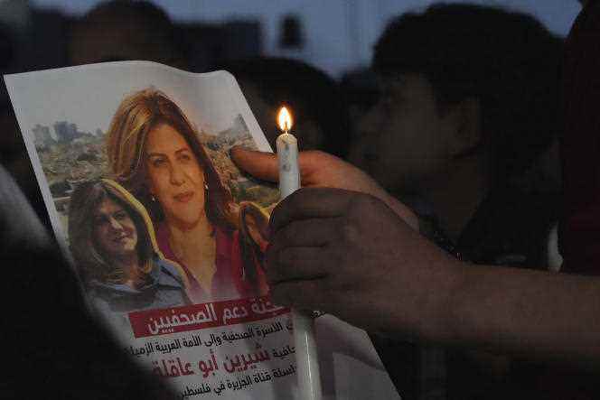 A Palestinian holds a candle and a photo of Al-Jazeera journalist Shireen Abu Akleh, killed in an Israeli raid in the West Bank on May 11 in Gaza.
