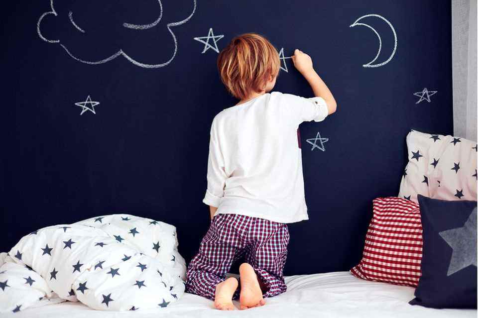 Design children's room: child paints on blackboard
