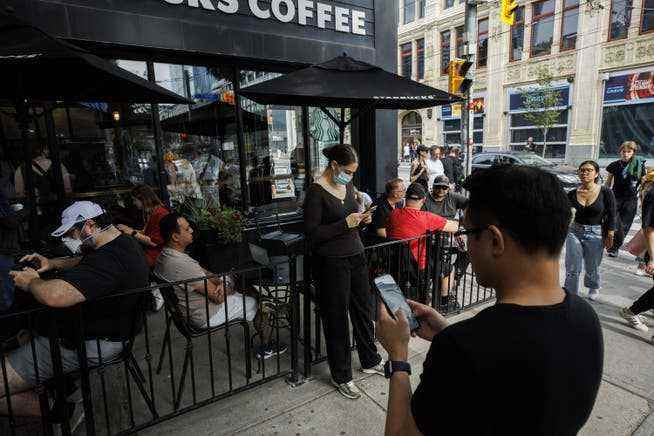 People use the Internet at a Toronto coffee shop amid a nationwide network outage by telecommunications company Rogers on Friday (7/8). 