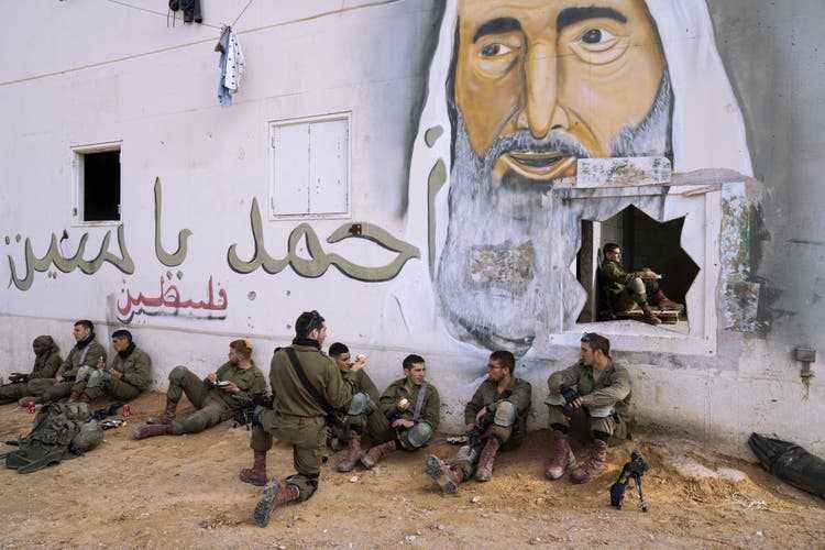 Israelische Soldaten bei der Mittagspause in einem Trainingszentrum für Häuserkampf, das auch als Mini-Gaza bekannt ist. Auf dem Wandbild ist der verstorbenen Hamas-Führer Sheikh Ahmad Yassin zu sehen.