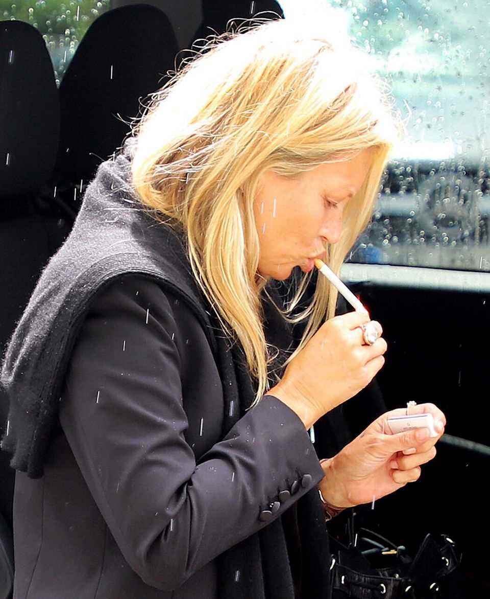 Am Flughafen von Mallorca raucht Kate Moss noch schnell eine Zigarette, bevor es mit dem Flieger wieder Richtung Heimat geht.