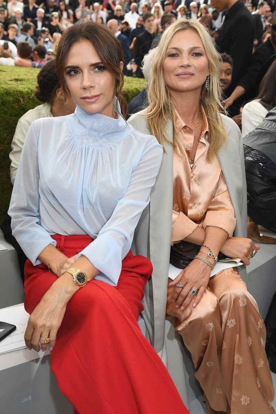 Auch Victoria Beckham zieht es für die Show von Dior nach Paris. Sie nimmt in einer knallroten Marlenehose und einer durchsichtigen, hellblauen Bluse Platz neben Kate Moss. 