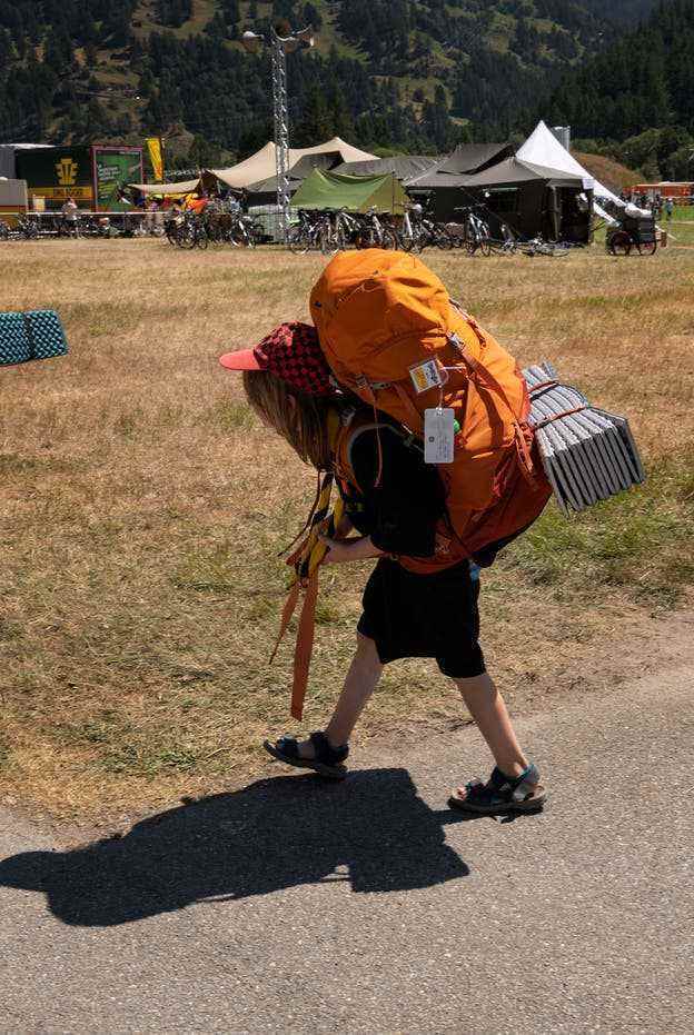 Ein Mädchen trägt sein Gepäck zum Lagerplatz.