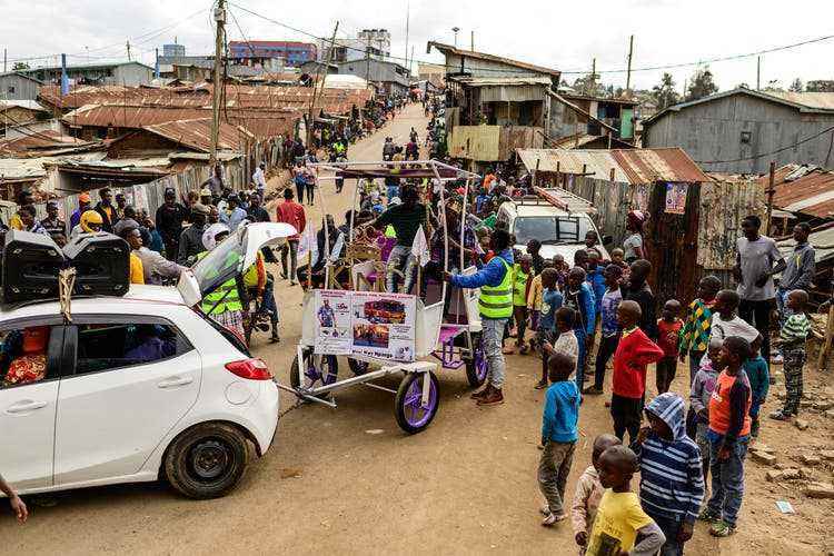A small Mazda pulls Martin Kivuva's carriage through Kibera.