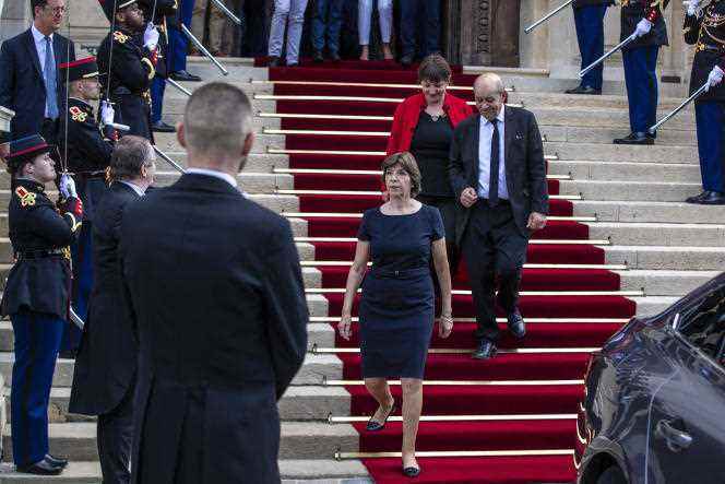 France's new foreign minister Catherine Colonna (center) escorts her predecessor Jean-Yves Le Drian after a handover ceremony at the foreign ministry in Paris on May 21, 2022 . 