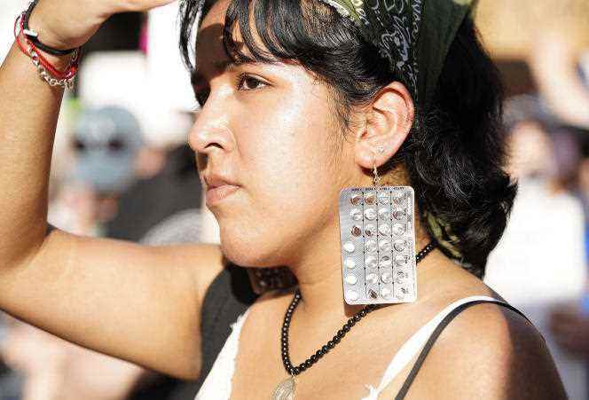 Esme Ledezma wears earrings made from birth control pills during a protest against the Supreme Court ruling, in Houston on June 24, 2022.