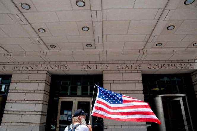 A Republican activist holds an American flag outside District Court on the first day of jury selection in the trial of former White House strategist Steve Bannon in Washington on July 18, 2022.