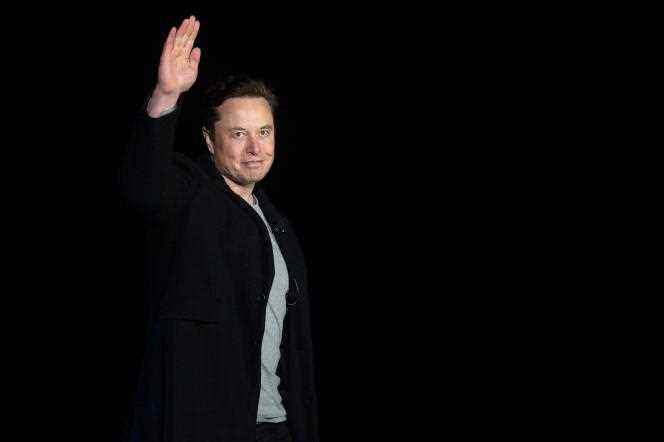 Elon Musk waves to reporters who came to listen to him at a press conference at SpaceX's 