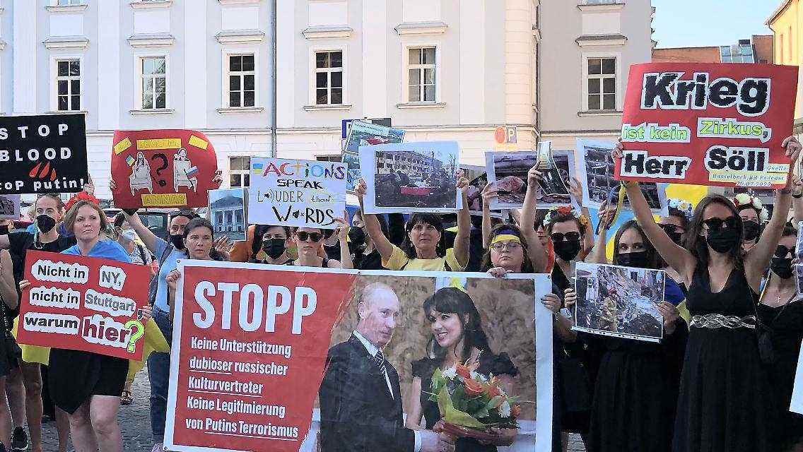 Auf Schildern war unter anderem „Anna wie wär es mit einem Benefizkonzert in der Ukraine?“ und „Nicht in NY, nicht in Stuttgart, warum hier?“ zu lesen.