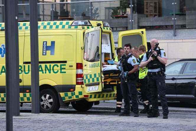 Police escort rescue workers to an ambulance in Copenhagen on Sunday, July 3, 2022.