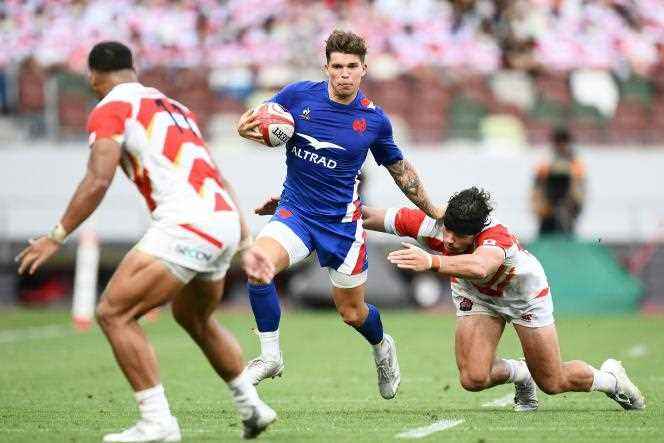 Matthieu Jalibert (center) avoids a tackle from Japanese Dylan Riley, during the second rugby union test match between Japan and France, at the National Stadium, in Tokyo, on July 9, 2022.