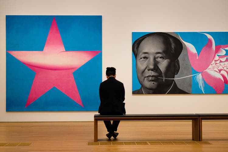 Ein Besucher in der Hauptausstellungshalle des M+ im November 2021 vor Werken aus der Serie «Rouge» des chinesischen Künstlers Li Shan.