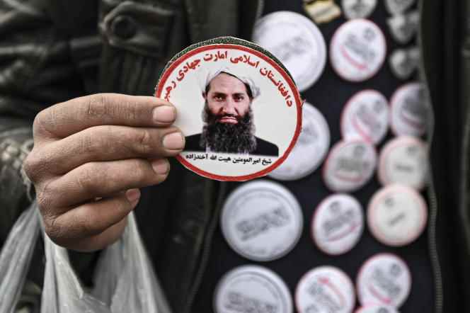 A man sells stickers of Taliban Supreme Leader Haibatullah Akhundzada at a market in Kabul on December 26, 2021. 