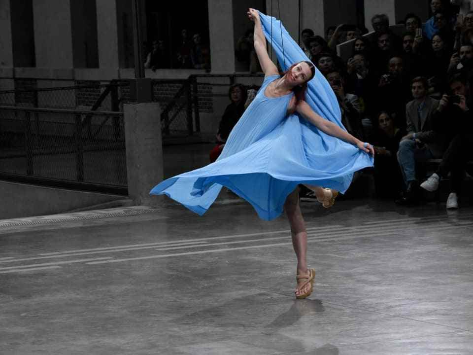 A woman in a blue dress at a show.