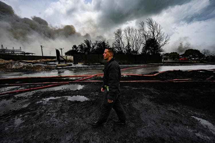 A firefighter walks through the area where a lightning strike caused a major fire.