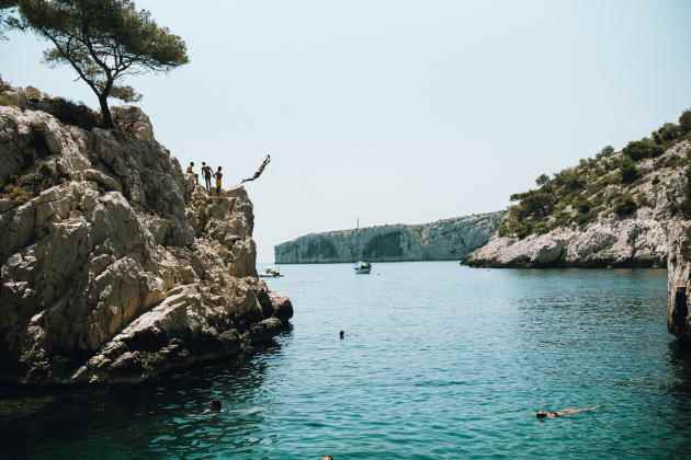 Young people jump from the cliff in the Calanque de Sugiton, in Marseille, on July 18, 2022.