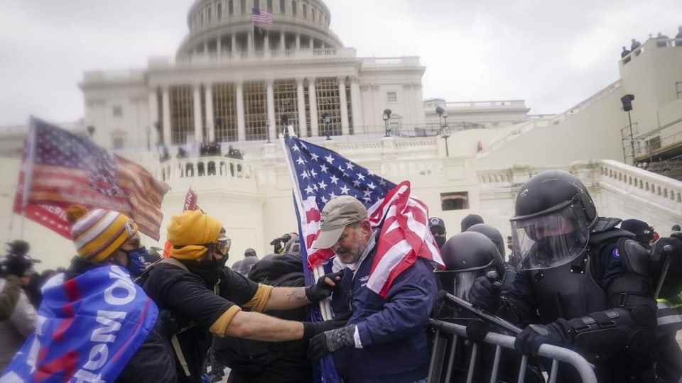 People storm the US Capitol carrying flags