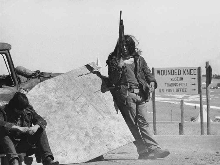 Members of AIM block the roads to Wounded Knee, South Dakota, in March 1973.