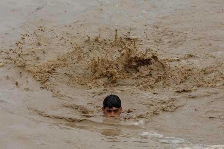 A man swims to safety in the Charsadda region.