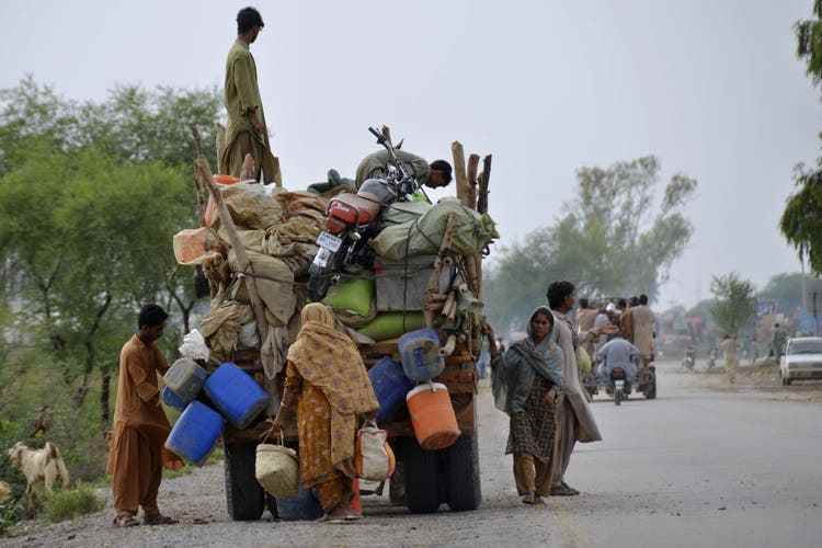 A woman loads her belongings onto a vehicle to go to a safe area after fleeing her flood-hit home in Nasirabad, a district in southwest Pakistan's Balochistan province.