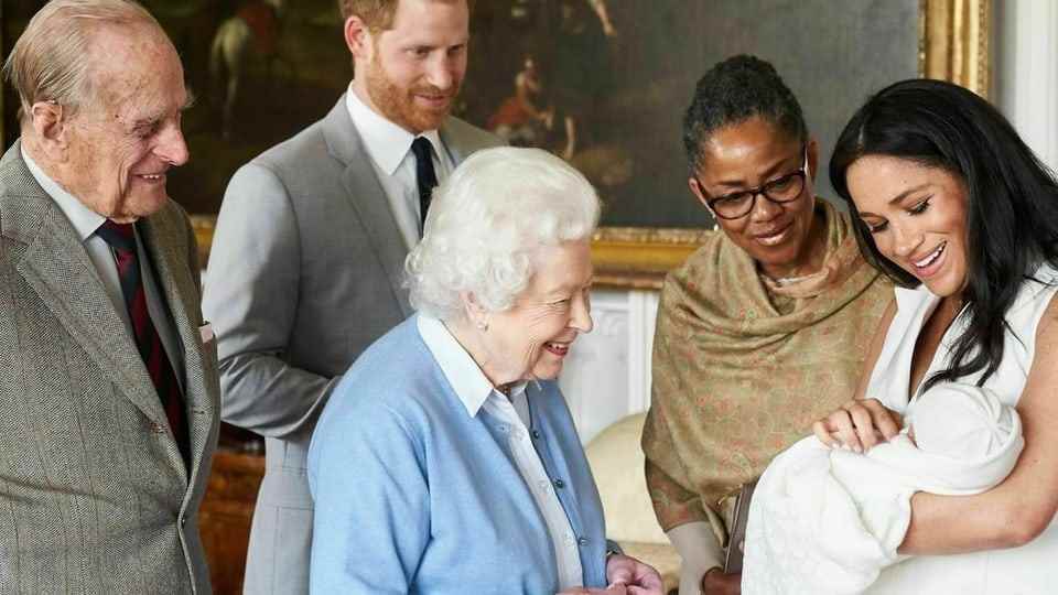 Queen looks at the baby.