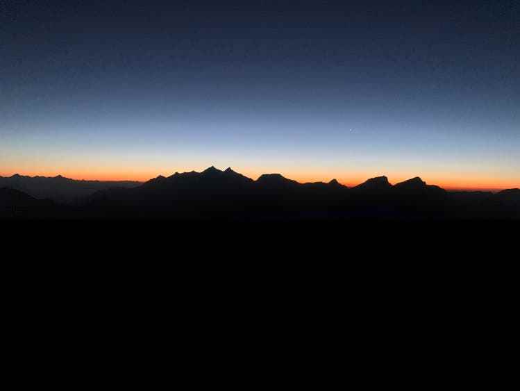 Momente, die im Gedächtnis bleiben: Die Morgensonne taucht die benachbarten Gipfel in ein rötliches Licht.