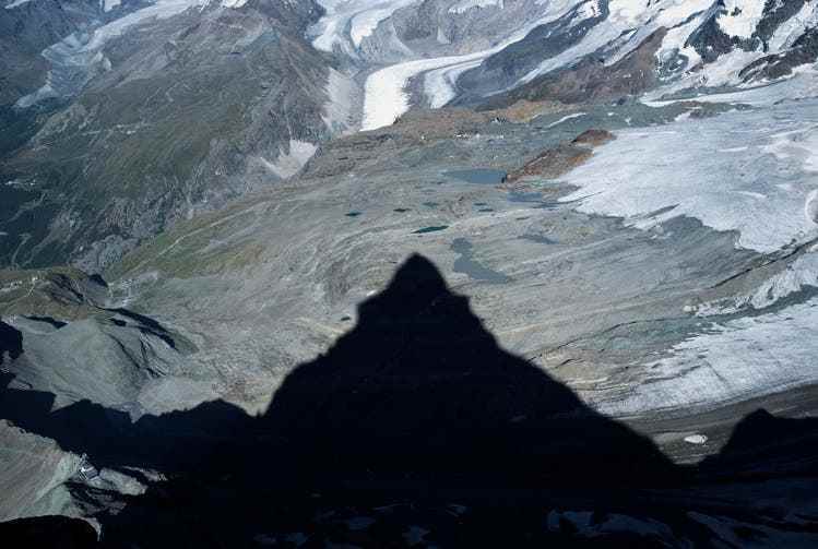 Am späten Nachmittag wirft das Matterhorn seinen langen Schatten talwärts. Im Hintergrund ist der Gornergletscher zu sehen.