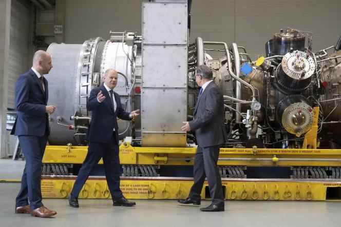 German Chancellor Olaf Scholz (center) and Siemens Energy CEO Christian Bruch (left) near a turbine for the Nordstream 1 pipeline in Mülheim, Germany, August 3, 2022. 