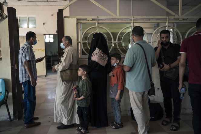 Palestinians line up to have their documents checked before crossing the Rafah border with Egypt in the southern Gaza Strip on June 6, 2021.