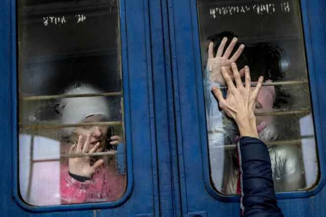 On a train to Poland from Lviv, a woman and her children bid farewell to their husband and father after fleeing their home in Kharkiv, March 6, 2022. 