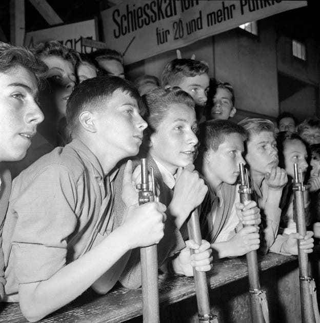 A group of young shooters share in the excitement of a shooting competition in 1955.