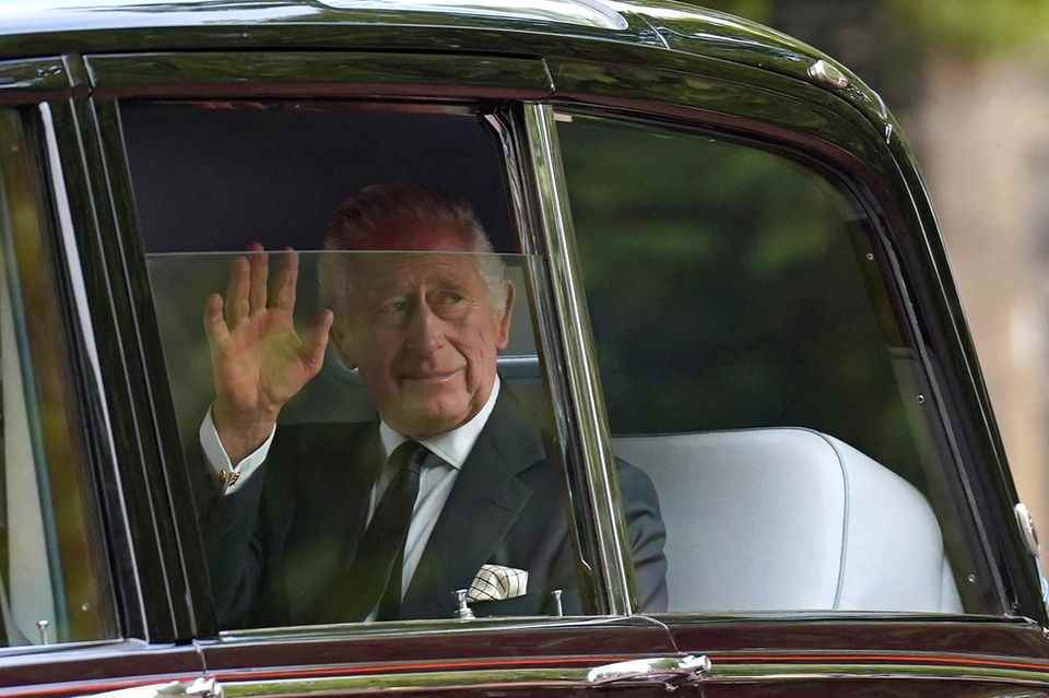 King Charles drives up to Buckingham Palace in a Rolls-Royce.