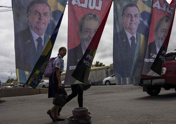 Schülerinnen laufen neben Fahnen, die für den amtierenden brasilianischen Präsidenten Jair Bolsonaro und den ehemaligen Präsidenten Luiz Inácio Lula da Silva werben.