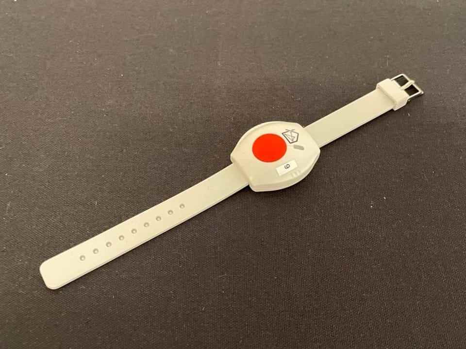 Emergency button for alarm activation on bracelet