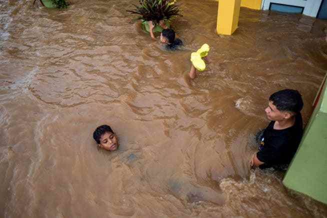 Several children play on a flooded street after the hurricane.