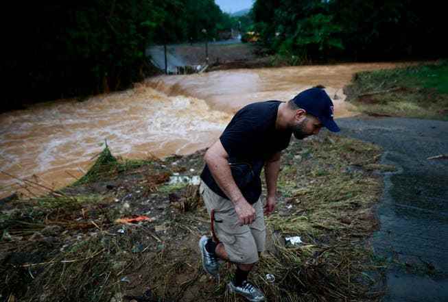 A man saves himself from the floods in Caguas on the shore.