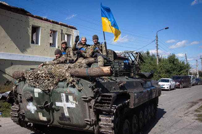 Ukrainian soldiers drive through the city of Izyum, recently liberated by Ukrainian forces.