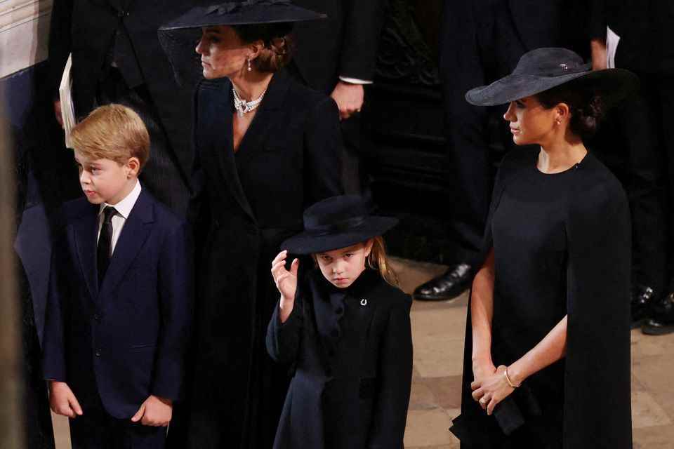 Princess Charlotte has a small brooch in the shape of a horseshoe on her black coat. 