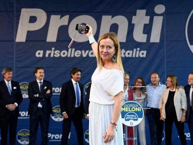Meloni at an election rally in Milan.  The motto of her party is: 