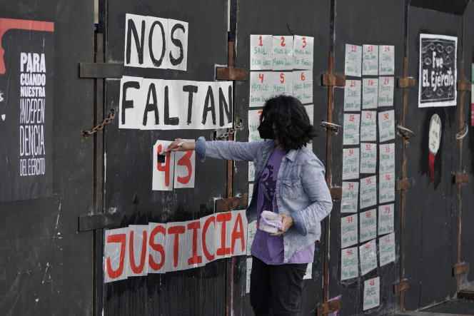 A young person sticks up sheets calling for justice for the disappearance of these 43 students.  In Mexico City, on the sidelines of the demonstrations, on September 26, 2022. 