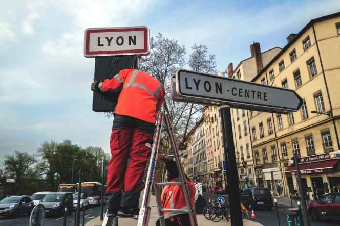 Municipal employees install signs corresponding to the new speed limit of 30 kilometers per hour in the perimeter of the city, in Lyon, on March 29, 2022.