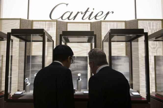 Visitors look at the stand of Cartier, owned by Swiss luxury group Richemont, during a fine watchmaking trade show in Geneva, January 18, 2016.