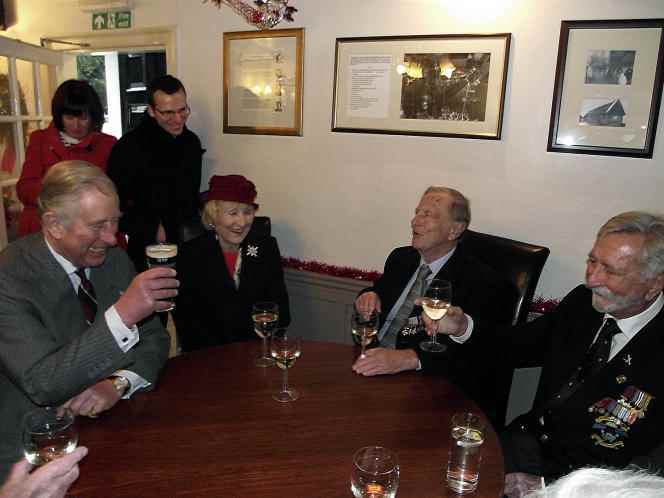 Prince Charles (seated left) in a pub in Tempsford, December 3, 2013. In the background, in black, journalist Eric Albert.