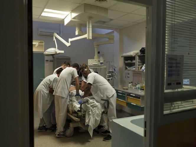 Caregivers place restraint straps on an agitated patient in the emergency department of the Argenteuil hospital center on September 2, 2022.