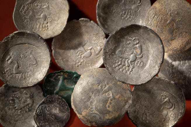 Keltische Silbermünzen aus Weiach: Sie zeigen auf der Vorderseite einen Apollokopf und auf der Rückseite ein Zweigespann mit Pferden und einem sitzenden Wagenlenker.
