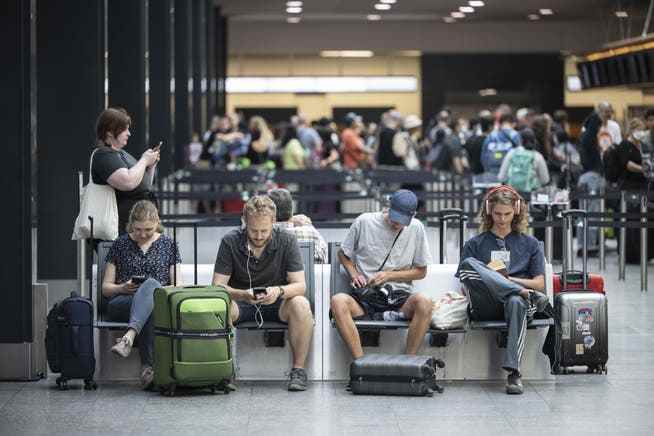 Lange Wartezeiten wegen technischer Probleme: wartende Menschen am Flughafen Zürich.