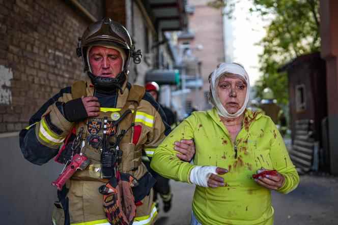 This photo released by the Ukrainian Emergency Service on October 10, 2022 shows a rescue worker helping an injured woman after several strikes in the Ukrainian capital kyiv.