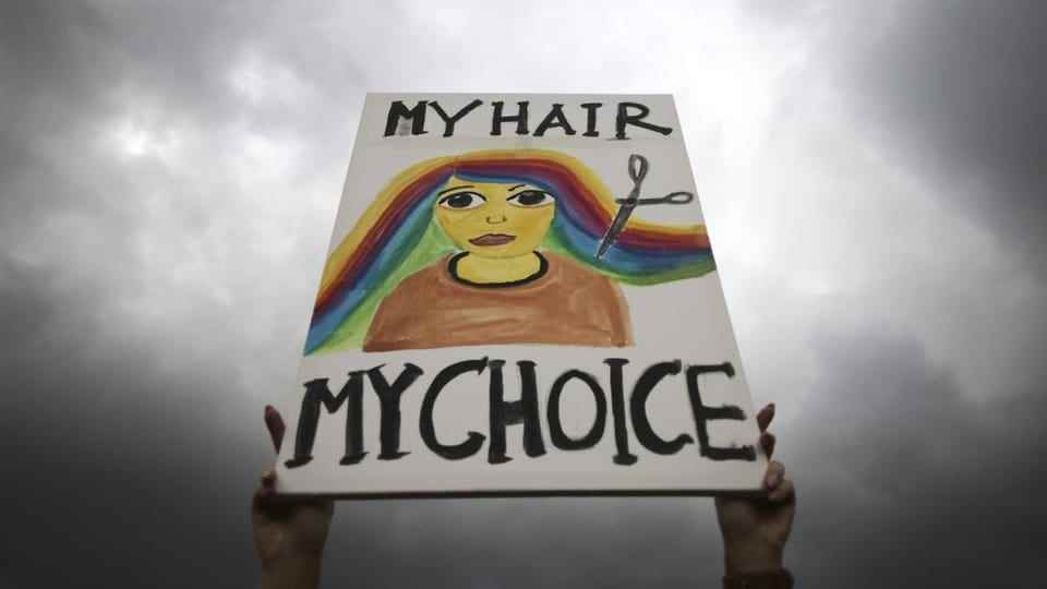A banner is shown.  On it: A pair of scissors cutting the rainbow-colored hair.  My hair, my choice.